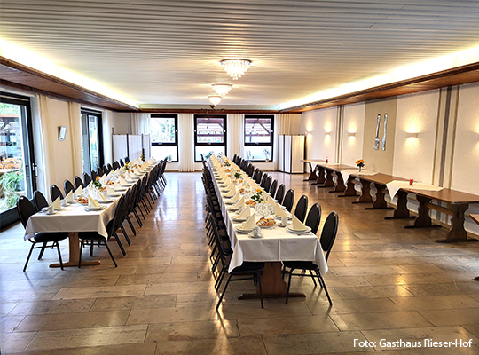 Ein gut gepflegter Saal mit langen Tischen und vielen Stühlen