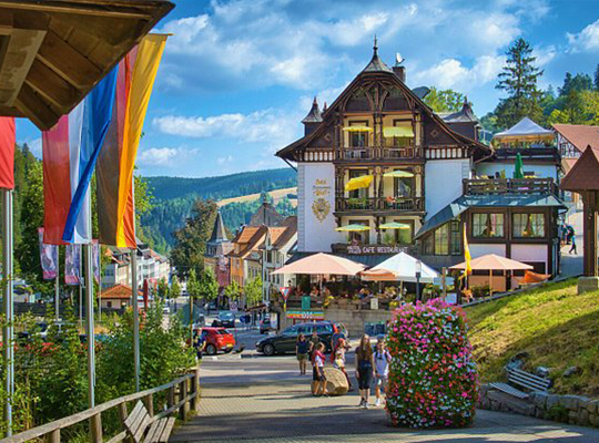 Blauer Himmel, Fahnen auf der linken Seite und ein großen imposantes Haus in der Mitte