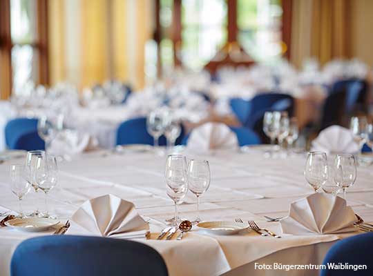 Gedeckter Tisch mit blauen Stühle, weißen Servietten und Gläsern beim Krimidinner Waiblingen