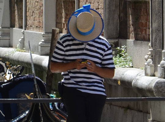 Ein Mann mit Strohhut und blau-weiß gestreiftem T-Shirt.