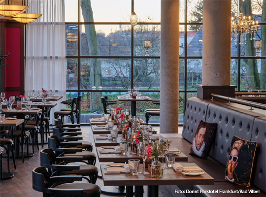 elegant eingedeckter Gastraum mit großer Glasfront