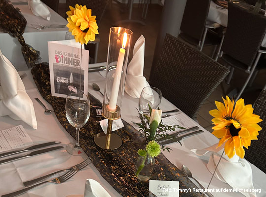 gedeckter Tisch mit aufgestellten Sonnenblumen