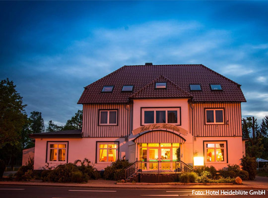 Außenansicht des Hotels Heideblüte bei Nacht.