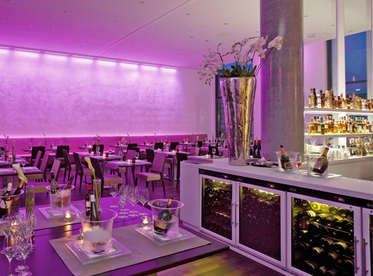Moderner Raum, lila beleuchtet, angenehme Atmosphäre, Bar und Weinregal