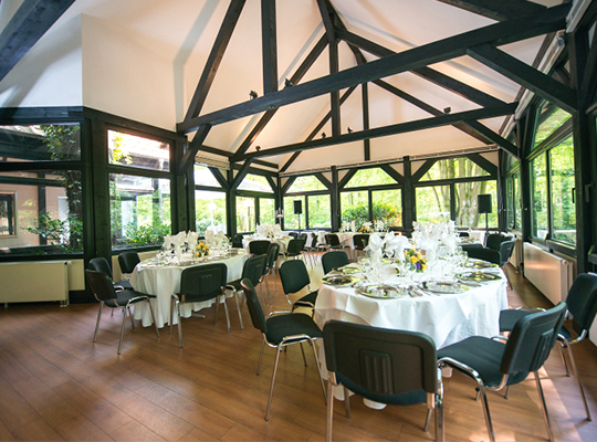 Großer Speisesaal mit großen Fenstern und Blick aufs Grüne beim Krimidinner Hannover