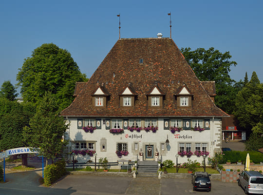 Schönes, historisches Gasthof-Gebäude mit Biergarten von der Straße aus fotografiert.
