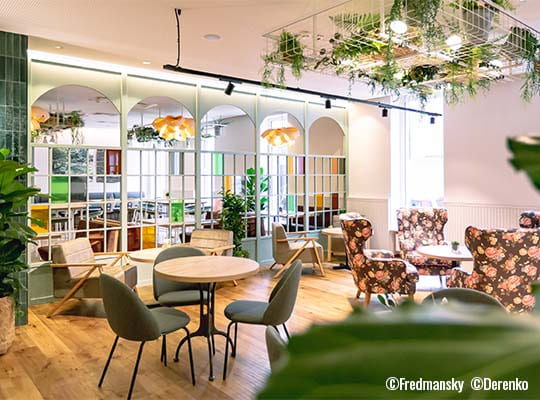 Liebevoll gestalteter Essensbereich mit vielen grünen Pflanzen, gemütlichen Sitzgelegenheiten und toller Raumgestaltung