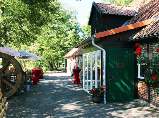Terrasse direkt am Mühlenteich mit altem Mühlenrad und schönes Hintereingang zum Restaurant.