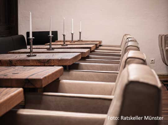 stilvolle Einrichtung mit Holztischen und Lederstühlen beim Krimidinner Münster im Ratskeller