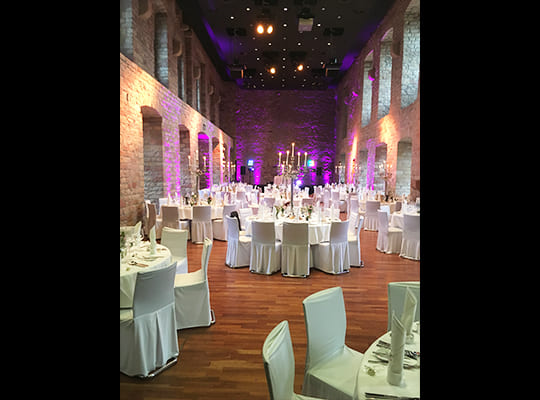 Festlich dekorierter Speisesaal mit violetten Lichtern an den Mauern des Schlosses. 