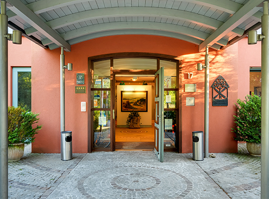 Einladener Eingangsbereich mit geöffneten Türen zum Romantik Hotel Gasthaus Rottner, Büsche umrahmen den Eingang