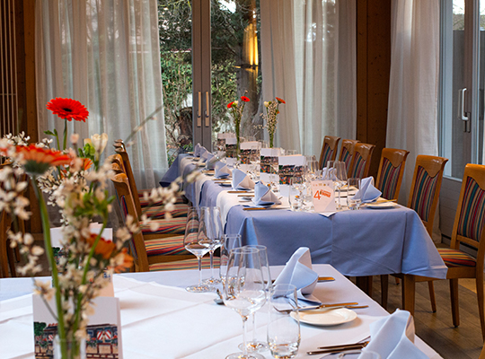Hellblaue Tischdekoration mit schönen Blumen und Blick auf die Terrasse bei unserem Krimidinner