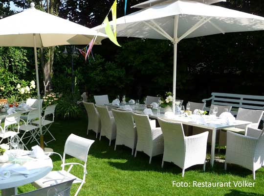 Gartenbereich des Restaurants Völker in Oppenheim, weisse Möbel und Schirme beim Krimidinner