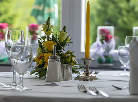 Weißes Gedeck und frische Frühlingsblumen im Hotel Waldesruh