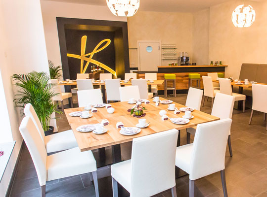 Modernes Design, Holztische und weiße Stühle im Restaurant des Korkenzieher beim Kriminal Dinner Schwaigern