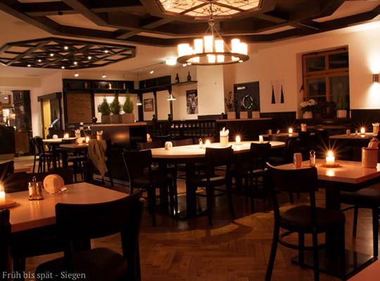 Urig trifft auf modern, schöne Inneneinrichtung im Restaurantbereich, mit vielen Kerzen.