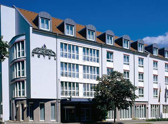 Außenfassade mit Baum des Erikson Hotel, blauer Himmel mit vereinzelter Wolke