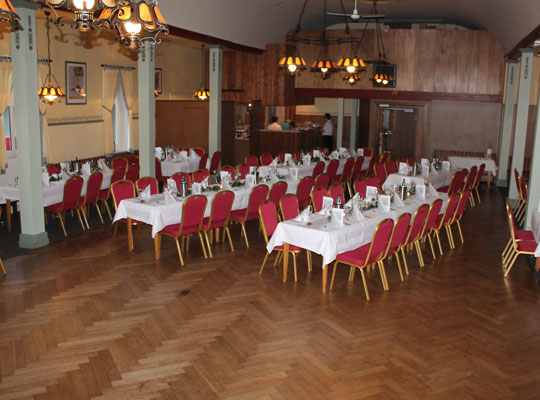 Großer Saal mit Holzboden, weißen Tischen und roten Stühlen, Tatort Stade