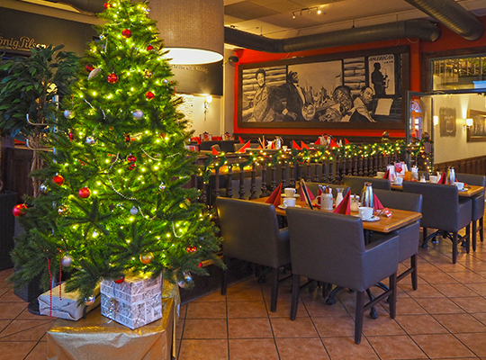 Gemütliches Ambiente und ein reichlich beschmückter Weihnachtsbaum im Restaurant Coopers