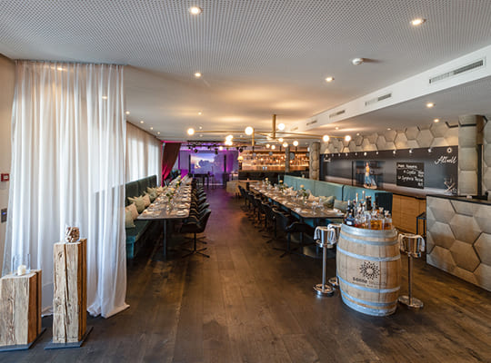 Chic und hochmodern gestalteter Restaurantbereich mit langen Tischtafeln angerichtet für das Kriminal Dinner.