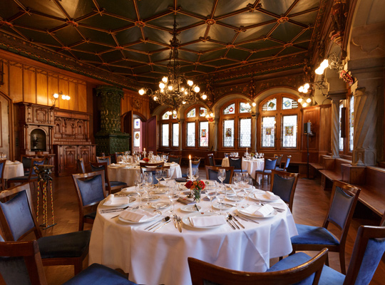 Historischer, gemütlicher Saal mit Holzverkleidung und festlichen Tischen im Zunfthaus zur Schmiden beim Krimidinner Zürich