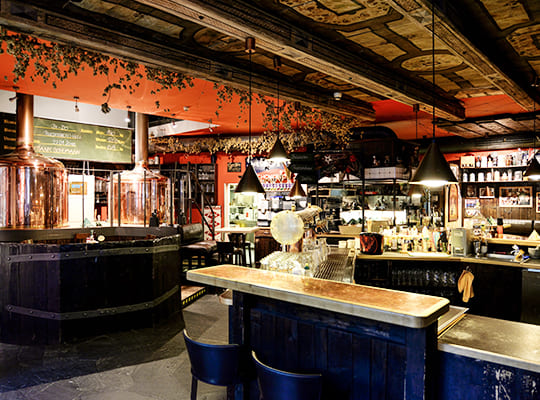 Restaurant und Bar-Bereich dekortiert in uriger Holzoptik kombiniert mit modern gestrichenen Wänden.