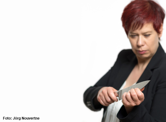 Frau tut so als würde sie ihre Finger mit einem Messer feilen - spannendes Krimidinner