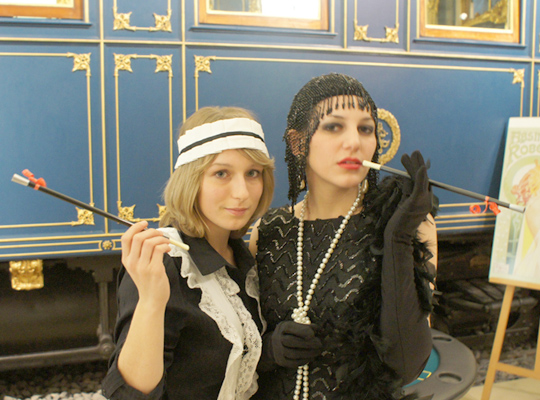 Zwei Frauen gekleidet im Stil der 20er Jahre mit Zigaretten - Krimidinner